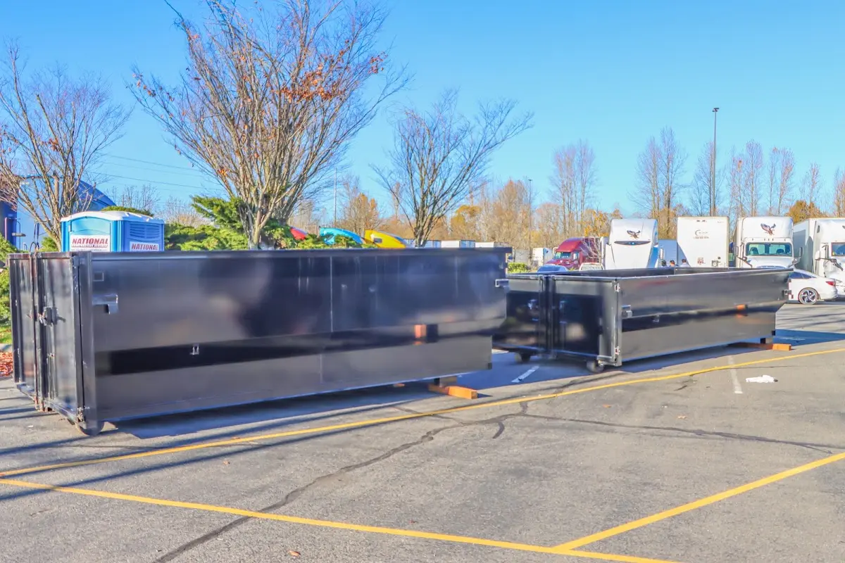 Professional dumpster rental service with roll-off container on residential driveway in Paradise